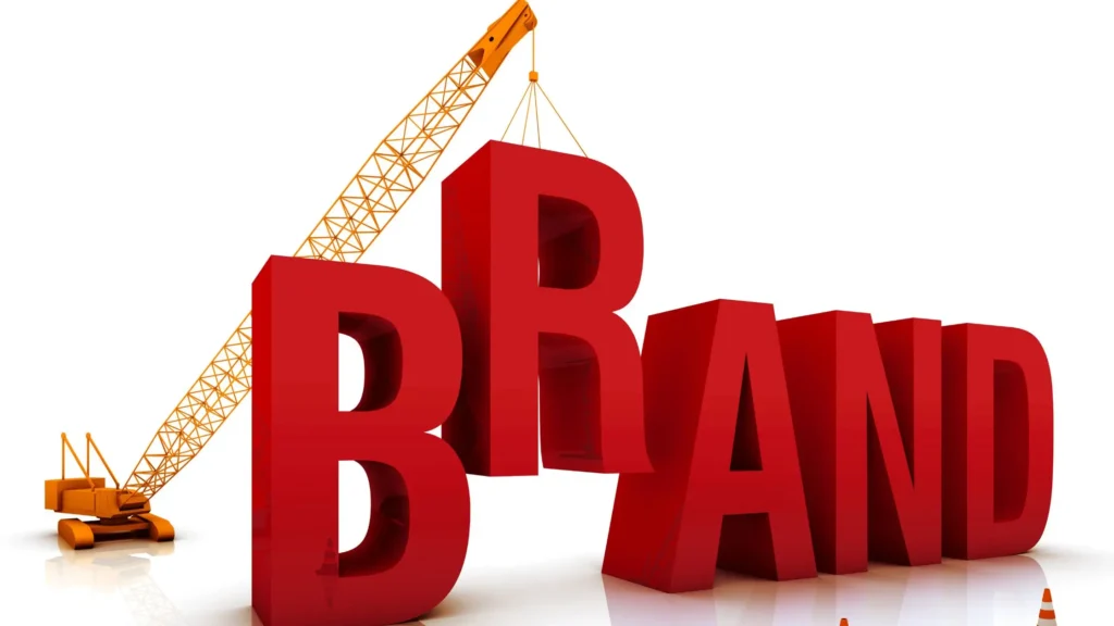 A picture of a toy lifter putting in the 'R' in between the rest of the letters to form the word BRAND