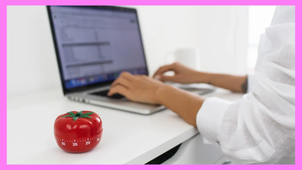 Woman writing with Pomodoro timer on desk for focused writing session