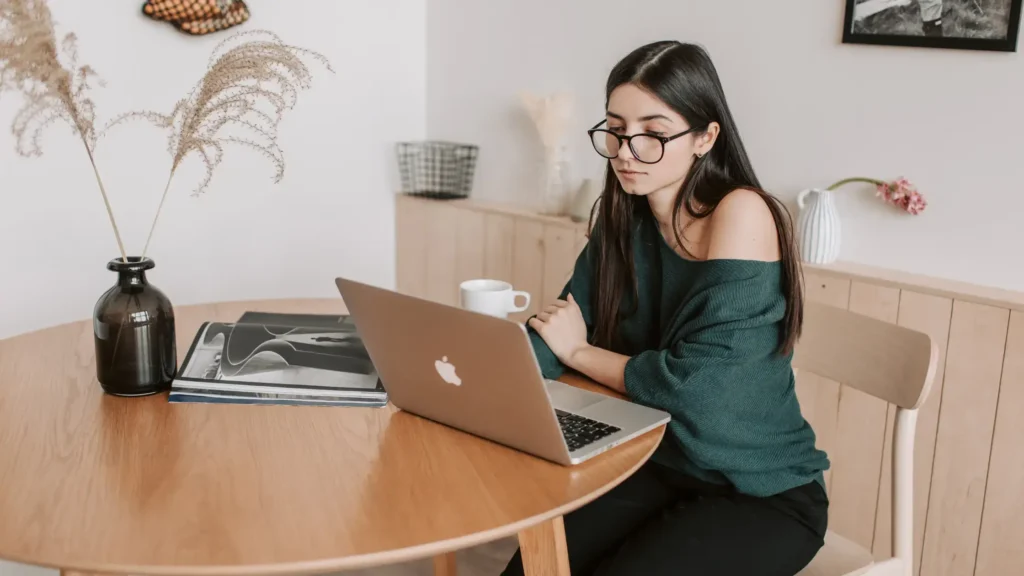 A woman looking into her laptop and studying The Complete Guide to SEO Freelance Writing Made Simple